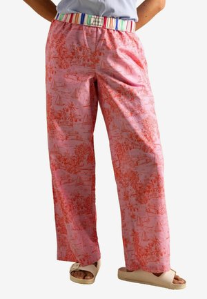 Pink wide-leg pants featuring a palm tree and sailboat pattern in red. The waistband has multicolored stripes and a branded label.