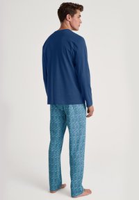 Heren slaapset bestaande uit een blauwe lange mouw top en een patroon van blauwe pyjamabroek met een geometrisch ontwerp. Gemaakt van een katoenmix.