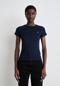 T-shirt aderente blu navy in cotone, con maniche corte e scollo rotondo. Piccolo logo sul petto. Texture liscia.