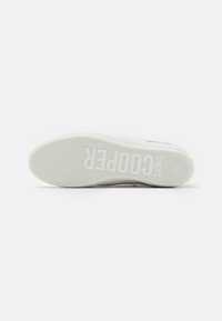 White sneaker sole with textured rubber for grip, featuring embossed "COOPER" branding and a minimalistic design. Flat and rounded shape.