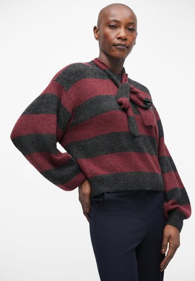 Pull rayé en tricot gris et bordeaux, avec un détail à nouer au niveau du col et une coupe décontractée avec des manches longues.