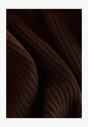 Tissu côtelé marron foncé avec une texture douce, présentant un motif ondulé et une légère brillance, plié pour montrer de la profondeur et de la dimension.