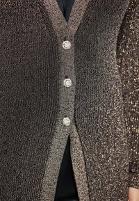 Cardigan nero metallico con un design a maglia testurizzata, scollatura a V e tre bottoni decorativi con un motivo floreale.