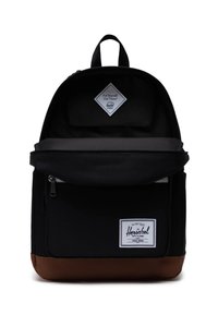 Zaino in tessuto nero con fondo in pelle marrone. Presenta un ampio scomparto principale e una tasca anteriore, oltre a un'etichetta con logo a forma di diamante bianco.