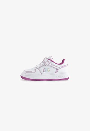 White athletic shoe with purple accents, Velcro strap, mesh panels, and logo detail. Features a textured rubber sole and stitched design.