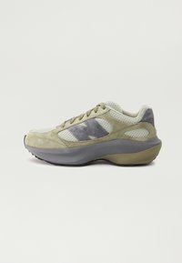 Sportssko med en lysegrøn mesh-overdel, suede-detaljer, mørkegrønne accenter og en tyk grå gummisål. Snørret design.