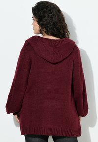 Cardigan lavorato a maglia bordeaux con cappuccio, caratterizzato da una vestibilità ampia, polsi e orlo a coste. Materiale testurizzato con un design spesso.