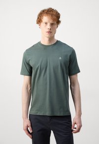 T-shirt vert à manches courtes en tissu de coton doux, avec un col rond et un petit logo blanc sur la poitrine gauche.