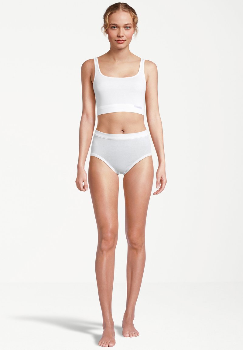 Weißes nahtloses Crop-Top und hoch taillierte Slips, präsentiert an einem Modell, aus weicher Baumwolle mit glatter Textur. Einfaches Design, ohne Muster.