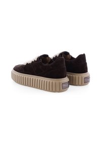 Braune Wildledersneaker mit einer dicken, gerippten beigen Sohle und cremefarbenen Schnürsenkeln. Sie verfügen über ein abgerundetes Design und ein dezent angebrachtes Logo an der Ferse.