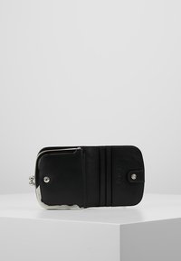 Portefeuille en cuir noir avec un fermoir en métal argenté, comportant des fentes pour cartes, une poche à pièces et une texture lisse. S'ouvre à plat pour un accès facile.