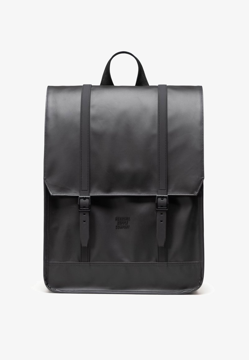 Svart läderryggsäck med en strukturerad design, platt topp, två justerbara remmar och en snapstängning. Textlogotyp på framdelen i botten.