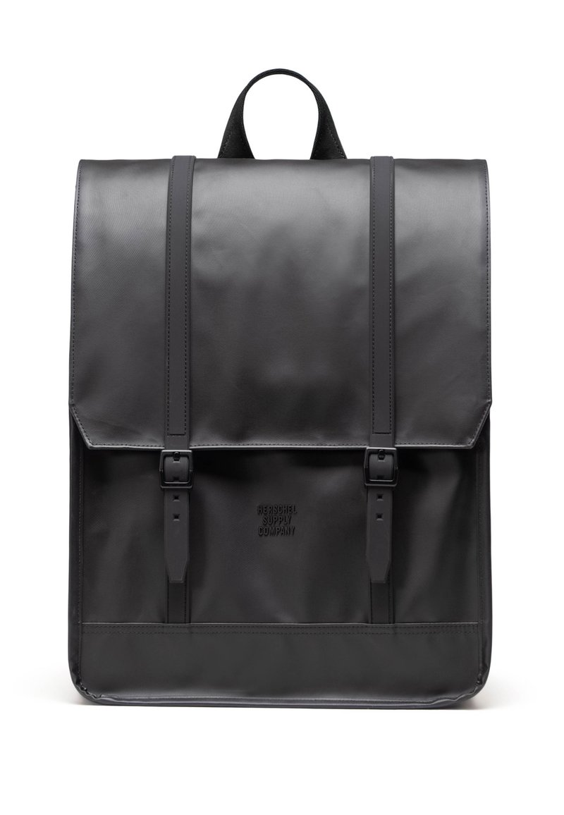 Zaino in pelle nera con design strutturato, parte superiore piatta, due spallacci regolabili e chiusura a scatto. Logo testuale nella parte anteriore in basso.