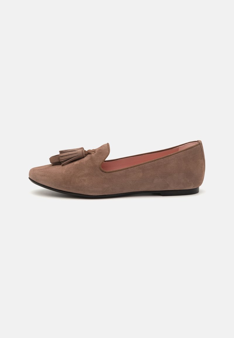 Mocassin plat en daim marron avec bout arrondi et double pompon sur le dessus, doté d'un petit talon noir et d'une doublure intérieure rose.