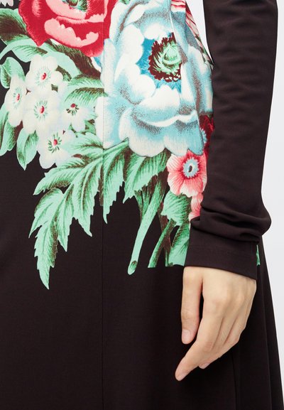Sukienka z długim rękawem z ciemnym tłem, na którym znajdują się żywe kwiatowe nadruki w odcieniach czerwieni, różu i niebieskiego oraz zielone liście, charakteryzująca się gładką teksturą.