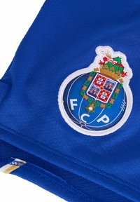 Tela azul con un logo bordado del FC Porto que presenta un escudo con una corona, acentos dorados y detalles intrincados sobre un fondo circular.