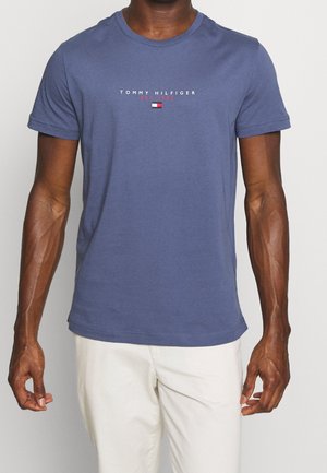 T-shirt en coton bleu à manches courtes, col rond, avec logo imprimé "TOMMY HILFIGER" avec des accents rouges et blancs sur la poitrine.
