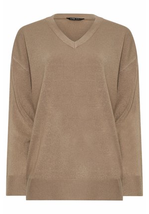 V-hals, oversized trui in een lichte tan tint. Zachte textuur met geribbelde accenten aan de mouwen en onderrand. Ontworpen voor een relaxte pasvorm.
