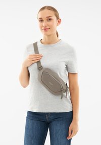 Borsa a tracolla grigia con texture liscia, forma rettangolare e chiusura con zip; presenta una tracolla regolabile e il logo del marchio sul davanti.