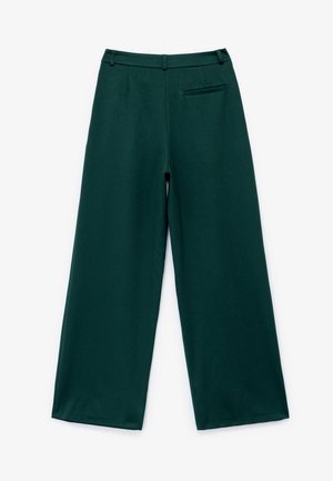 Wide-leg trousers in dark green, made from smooth fabric. Features a tailored waistband, hidden side pockets, and a back pocket detail.