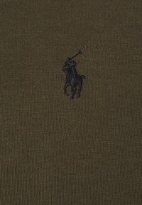 Olivově zelená pletená polokošile s texturovaným povrchem a vyšitým černým logem hráče póla na koni.