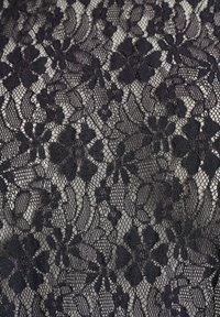 Čierna čipková látka s kvetinovým vzorom, ktorá obsahuje zložitý motív kvetov a listov, s jemnou, otvorenou štruktúrou a výraznou priesvitnosťou.