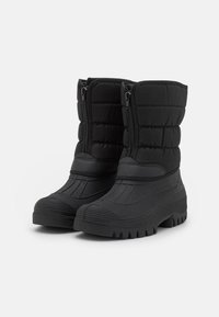 Par de botas de invierno negras aisladas con suelas texturizadas gruesas y cremalleras frontales, diseñadas para condiciones frías y nevadas.