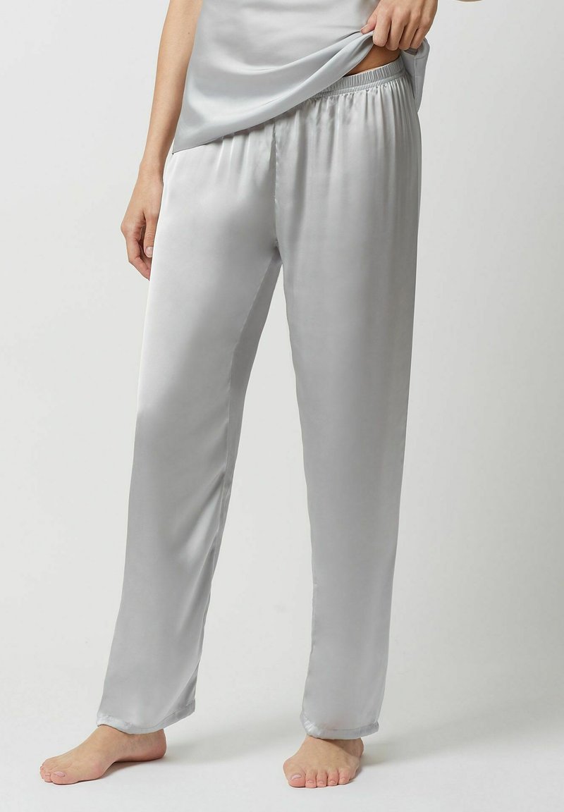 Pantalon de pyjama en satin gris avec une taille élastique, coupe droite et texture lisse. Le tissu a un léger brillant et se drape facilement.