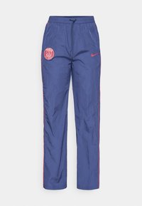 Blå Paris Saint-Germain Nike träningsbyxor med röda logopatchar, röd piping längs sidorna och resårmidja med dragsko.