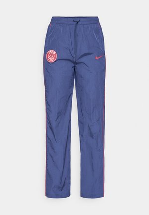 Pantaloni da allenamento Nike Paris Saint-Germain blu con toppe rosse del logo, piping rosso lungo i lati e vita elastica con cordino.