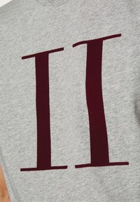 Gray short-sleeve t-shirt featuring a large, deep red "II" print. Soft cotton material with a smooth texture. Simple crew neck design.