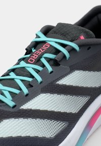 Sportschoenen met een donkergrijze textielen bovenkant, aqua veters en reflecterende zilveren accenten. Beschikt over een gevoerde zool met een roze en aqua verloop.
