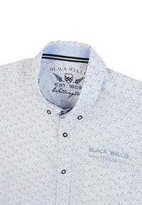 Chemise blanche à manches courtes avec motif à pois multicolores, col boutonné et logo brodé sur la poche poitrine.