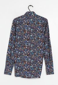 Camisa de manga corta con un fondo azul marino y un colorido patrón de flores y animales, hecha de una tela ligera con una textura suave.