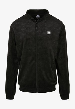 Musternik kootta must fleece-jope, millel on tõmblukk, tekstuuriga muster, tõstetud krae ja soonikkoes mansetid. Vasakul rinnal logo teip.