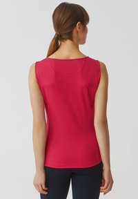 Top senza maniche, aderente, in tessuto rosa brillante con una texture liscia. Presenta un colletto arrotondato e dettagli di cucitura minimi. Vista posteriore mostrata.