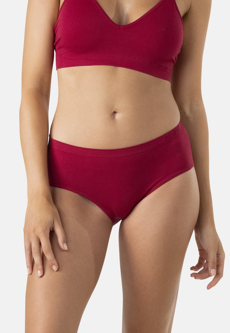 Ensemble de bralette et slip assorti en coton rouge. Tissu doux et extensible avec une texture lisse. Bords sans couture sans matériel ou motifs visibles.
