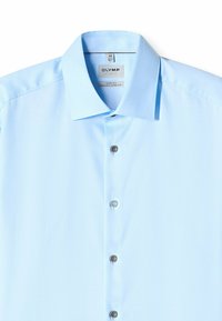 Hellblaues Hemd mit klassischem Kragen, fünf Knöpfen und glatter Textur. Das Etikett zeigt Marken- und Passforminformationen an.