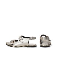 Metalen zilveren sandalen met twee verstelbare gespen, open teen ontwerp, en een gevlochten zool met zwarte en tan strepen.