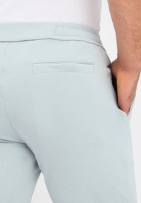 Lichtblauwe joggingsbroek van een zachte katoenmix, met een gladde textuur, een elastische tailleband en een enkele achterzak.