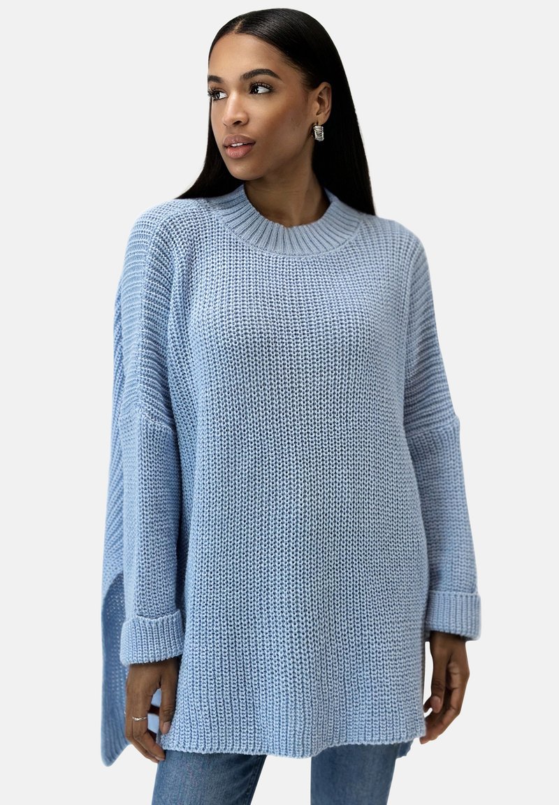 Helle blaue Strickpullover mit rundem Ausschnitt, überschnittenen Schultern und gerippten Bündchen. Verfügt über eine lockere Passform und strukturierte Stoffe.