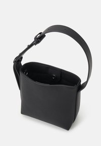 Sac seau en cuir noir avec large bandoulière réglable et fermeture par bouton-pression, montré ouvert pour révéler la poche intérieure.