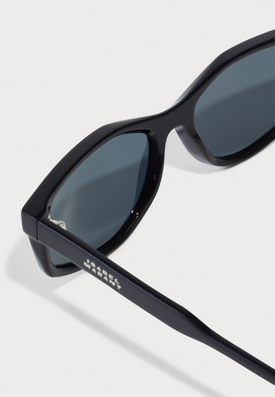 Ochelari de soare negri cu rame unghiulare, lentile întunecate și logo gravat pe lateral. Material din plastic neted, design minimalist.