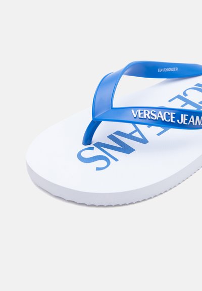 Бели джапанки с сини презрамки с текст "VERSACE JEANS" и частичен голям син текст "JEANS" на ходилото.