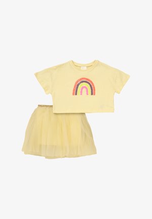 Gult outfit til småbørn med kortærmet crop top med farverigt regnbuemotiv og matchende tylskørt med guldfarvet elastik i taljen.