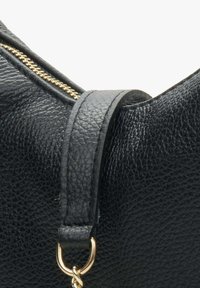 Czarna skórzana torebka o teksturowym wykończeniu, ze złotym suwakiem i mocnym paskiem na ramię z metalowym uchwytem.