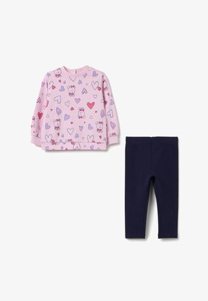 Helles rosa Langarmshirt mit Cartoonfiguren und Herzmustern, kombiniert mit einfarbigen, navyblauen Stretchleggings. Aus weichem Baumwollstoff.