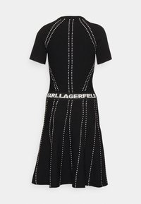 Black knit dress featuring short sleeves, vertical white stitching lines, and a branded waist with "KARL LAGERFELD" in white lettering.