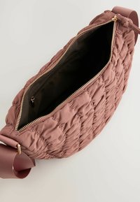 Gequilted roze schoudertas met een ritssluiting, stoffen schouderband en een gevoerde binnenkant met een binnenzak.