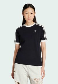 Navy cotton t-shirt with white ribbed crew neck and sleeve cuffs, featuring three white stripes on shoulders and a small logo on the chest.